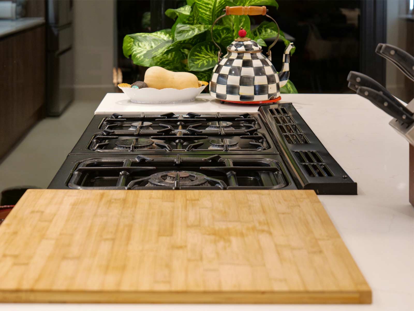 A Scandi kitchen island worktop with stovetop and integrated chopping board