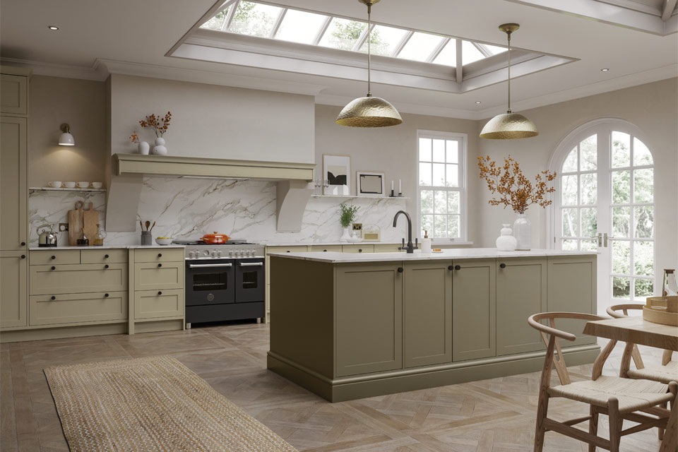 A moss green kitchen with white counters and wooden flooring