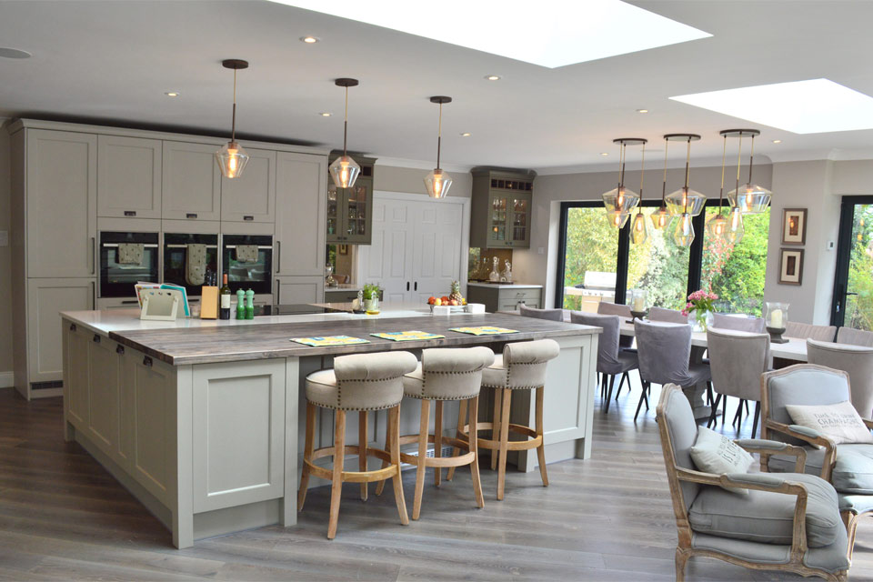 A neutral sea green kitchen with a green kitchen island
