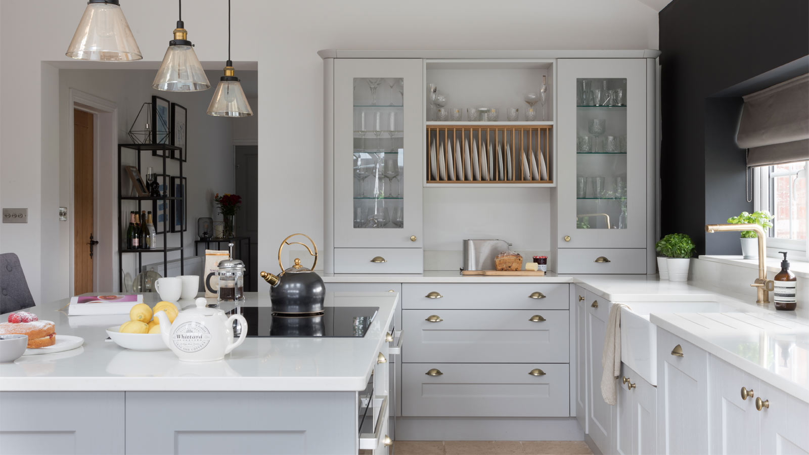 A Nancy Meyers kitchen with Shaker kitchen cupboards and marble worktops