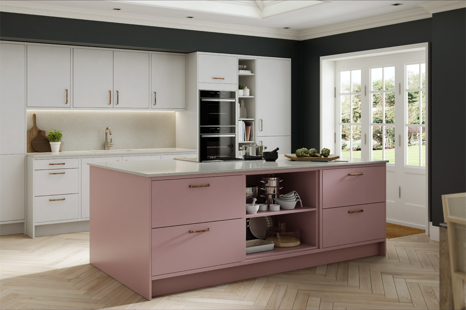 A pink and sage kitchen with pink and white kitchen units