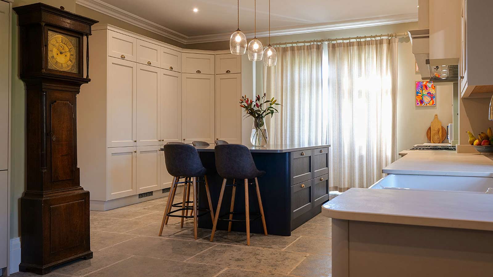 A white Victorian kitchen with a blue kitchen island and an old-money look